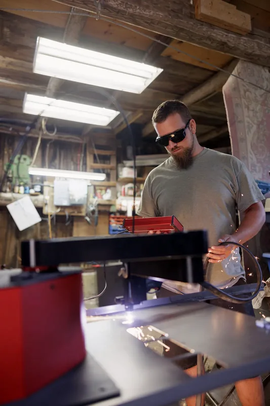 Un métallier au travail sur sa machine